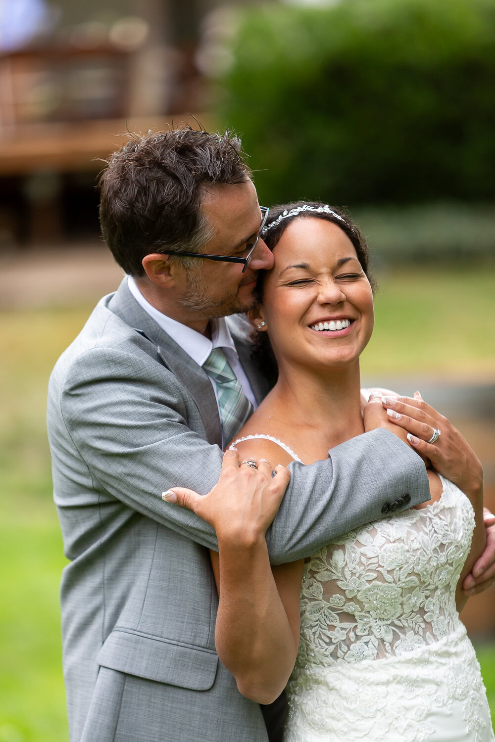 Elegant wedding photography capturing joyful couple embracing outdoors, highlighting love and wedding attire.