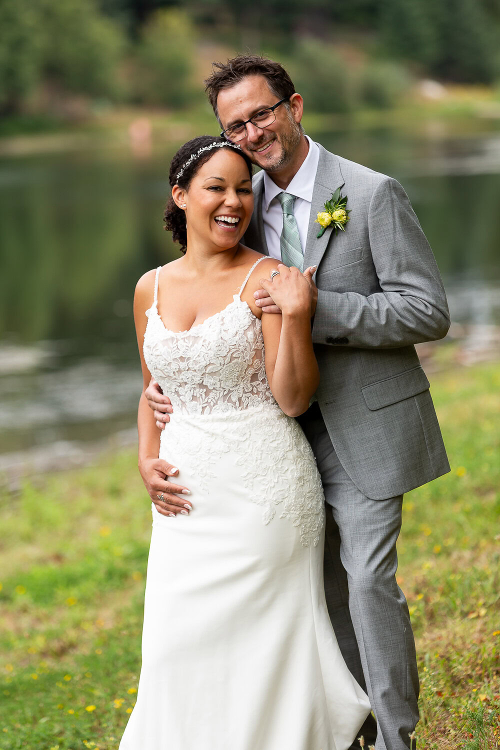 Elegant wedding couple smiling outdoors by a river, showcasing wedding photography at Nallayer Studios.